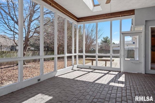 unfurnished sunroom featuring a skylight