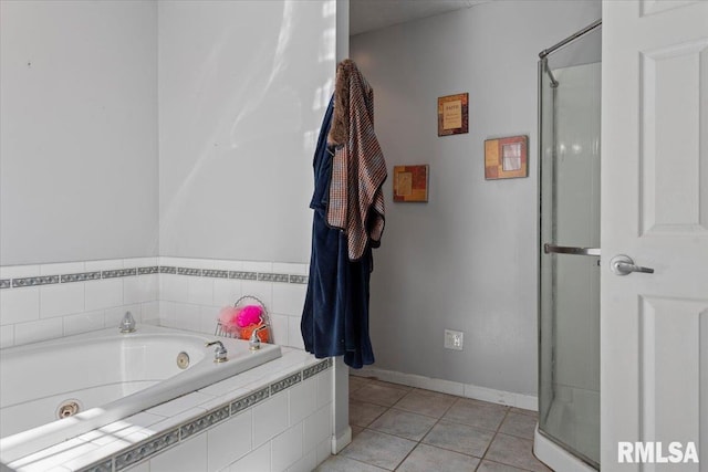 bathroom featuring tile patterned floors, a tub with jets, a stall shower, and baseboards