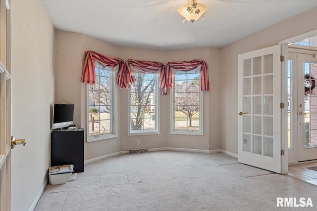 unfurnished dining area with carpet flooring, french doors, baseboards, and visible vents