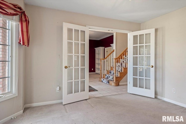 unfurnished room with stairway, carpet flooring, french doors, and baseboards