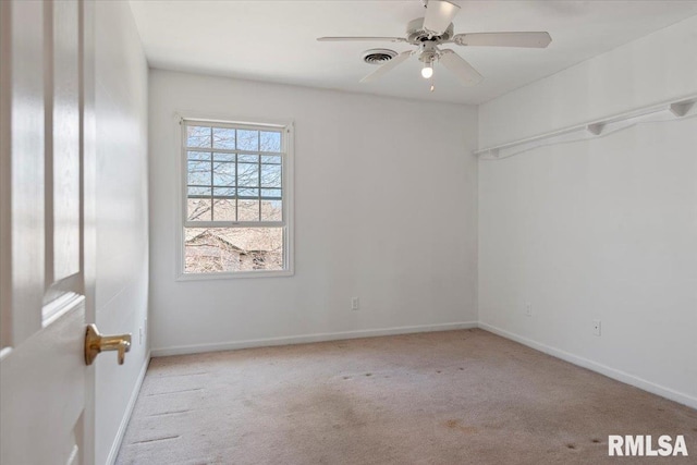 carpeted spare room featuring a ceiling fan, visible vents, and baseboards