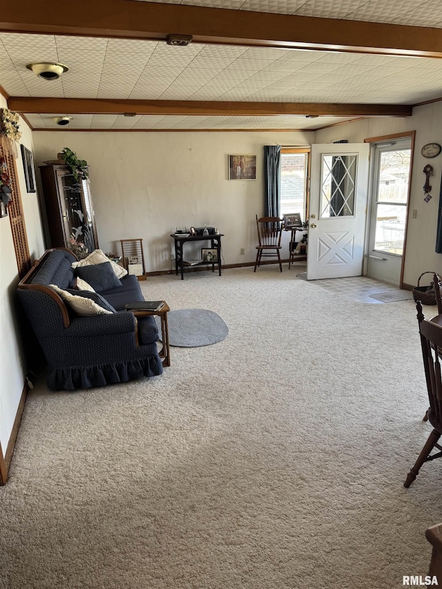 carpeted living area with beamed ceiling, baseboards, and a wealth of natural light