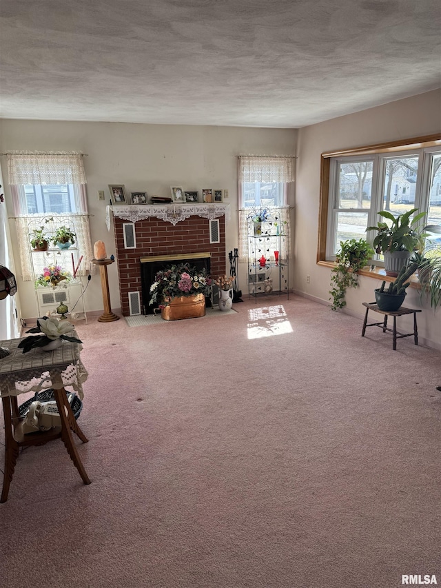 living area with carpet, a fireplace, and a textured ceiling