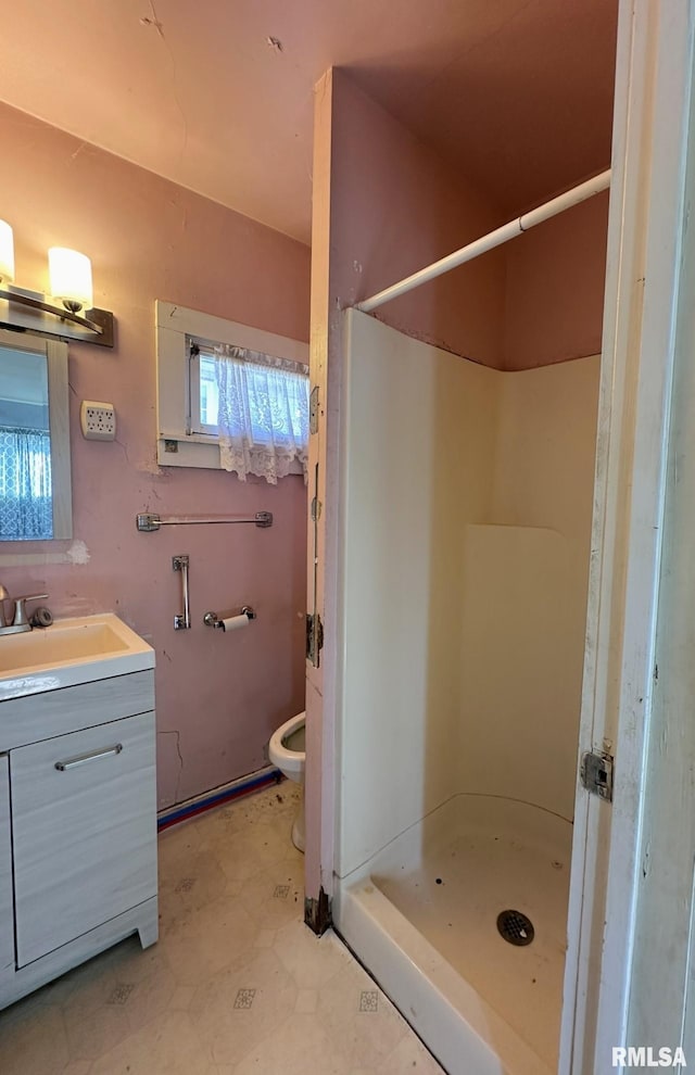 bathroom featuring tile patterned floors, toilet, a stall shower, and vanity