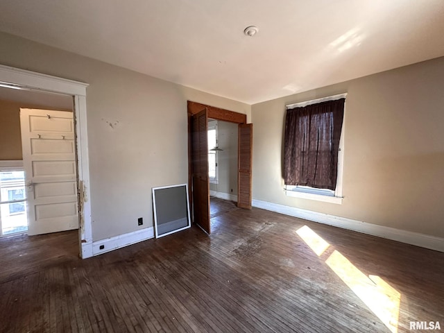 spare room with dark wood finished floors and baseboards