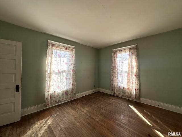 unfurnished room featuring baseboards and hardwood / wood-style flooring