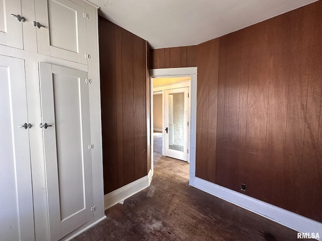 unfurnished bedroom with wooden walls and baseboards