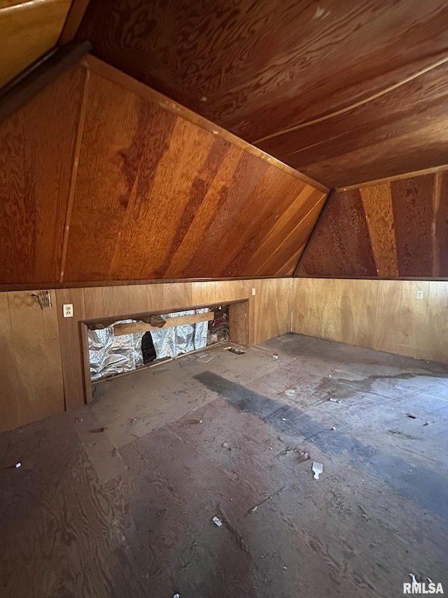 additional living space featuring lofted ceiling and wooden walls