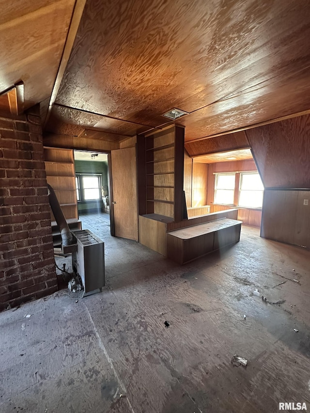 additional living space featuring wooden walls, wood ceiling, a wood stove, and vaulted ceiling