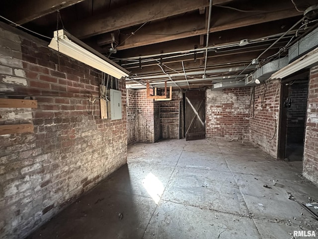 unfinished basement with electric panel and brick wall