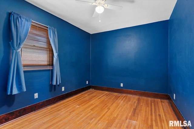 spare room with wood finished floors, baseboards, and ceiling fan