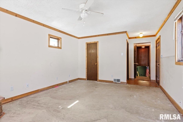 unfurnished room with visible vents, unfinished concrete floors, a textured ceiling, and baseboards