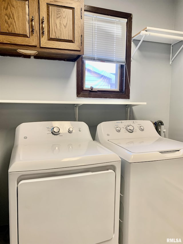 washroom featuring cabinet space and separate washer and dryer