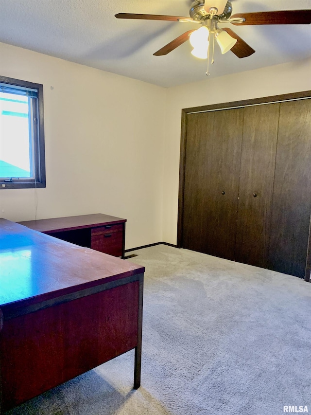 carpeted bedroom with a closet, a textured ceiling, and ceiling fan