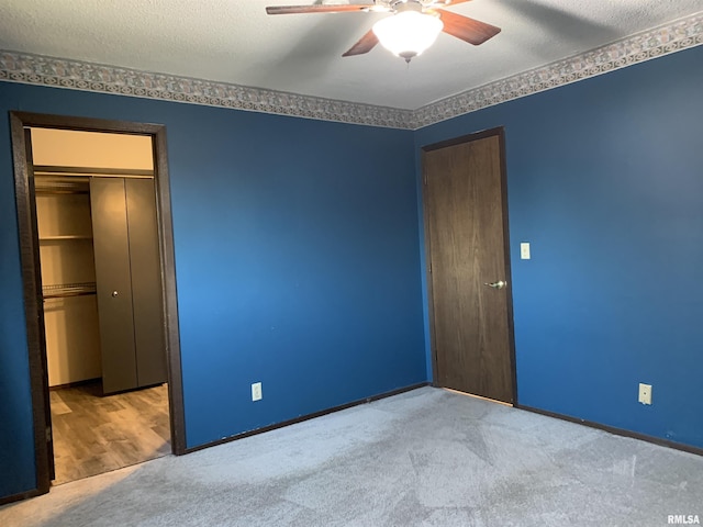 unfurnished bedroom with a closet, carpet flooring, a textured ceiling, and a ceiling fan