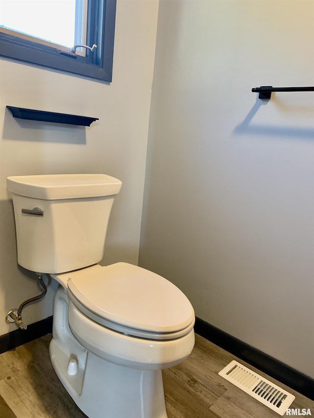 bathroom featuring visible vents, baseboards, toilet, and wood finished floors