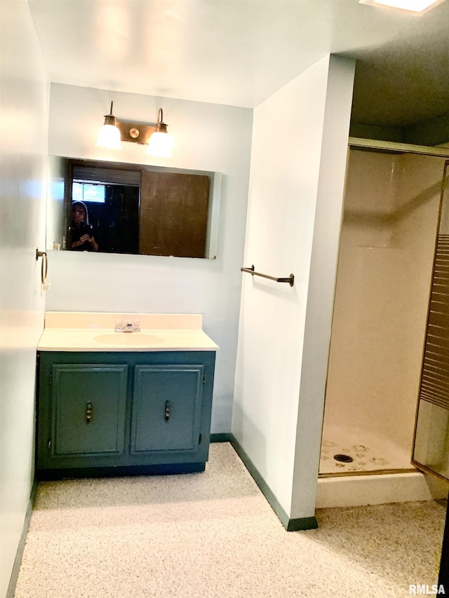 bathroom featuring a shower stall, vanity, and baseboards