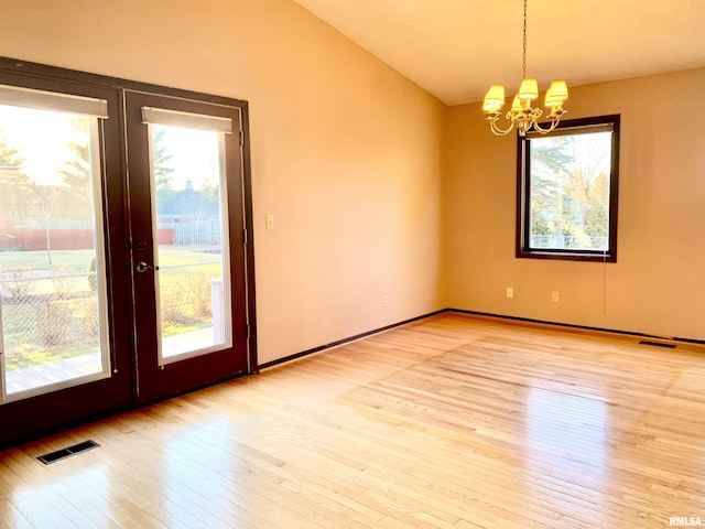 unfurnished room featuring visible vents, lofted ceiling, light wood-style flooring, and french doors