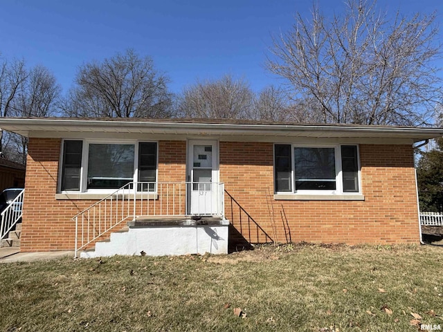 view of front of house featuring brick siding and a front lawn