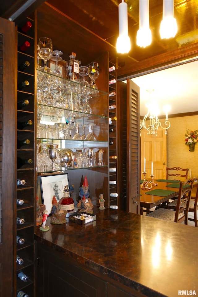 bar featuring an inviting chandelier and a dry bar