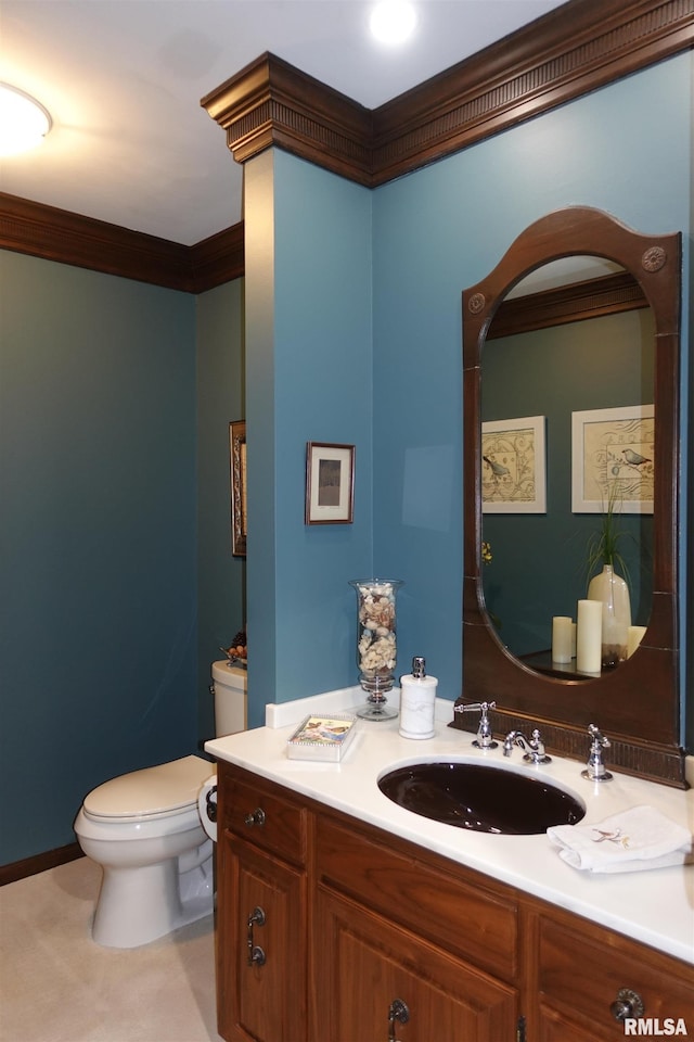 bathroom featuring toilet, vanity, and ornamental molding