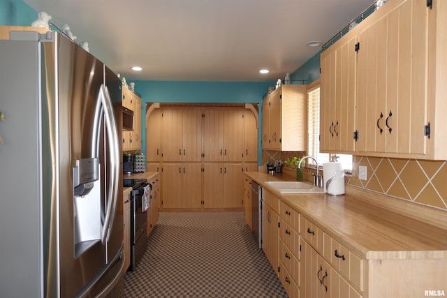 kitchen featuring recessed lighting, a sink, stainless steel appliances, light countertops, and tasteful backsplash