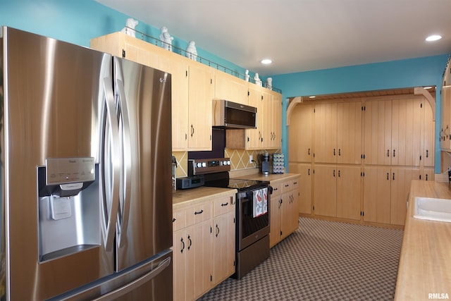 kitchen with light brown cabinets, recessed lighting, light countertops, appliances with stainless steel finishes, and backsplash