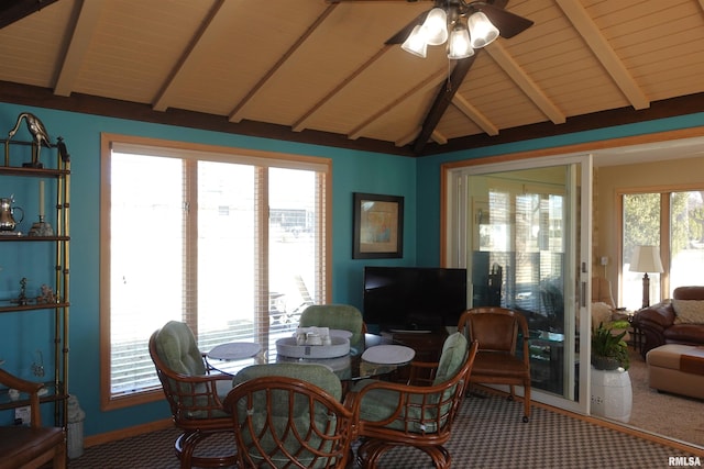 carpeted dining room featuring vaulted ceiling with beams and a ceiling fan