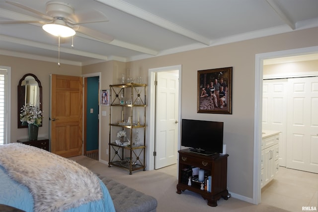 bedroom with baseboards, beam ceiling, light colored carpet, and ensuite bathroom