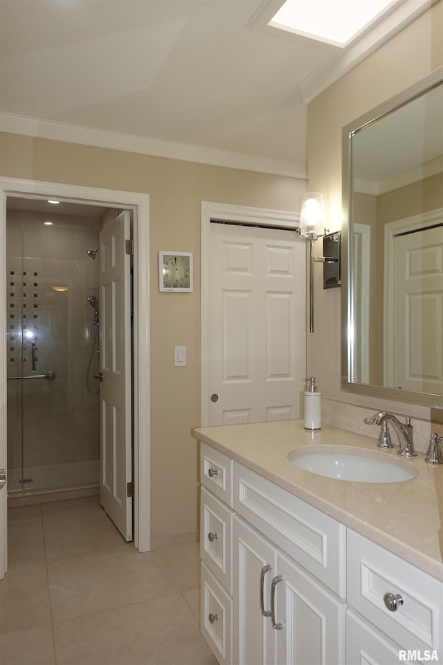 bathroom with vanity, a skylight, a stall shower, ornamental molding, and tile patterned floors