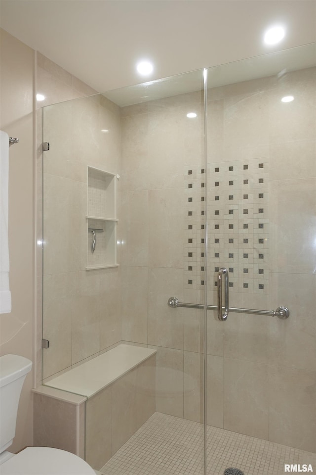 bathroom with recessed lighting, toilet, and a stall shower