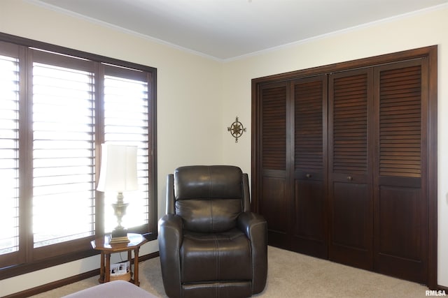 sitting room featuring crown molding, light colored carpet, and baseboards