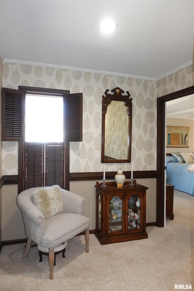 sitting room with a wainscoted wall, carpet floors, crown molding, and wallpapered walls