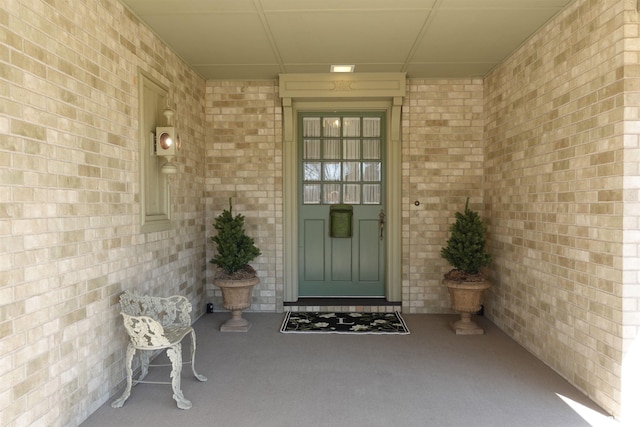 view of exterior entry with brick siding