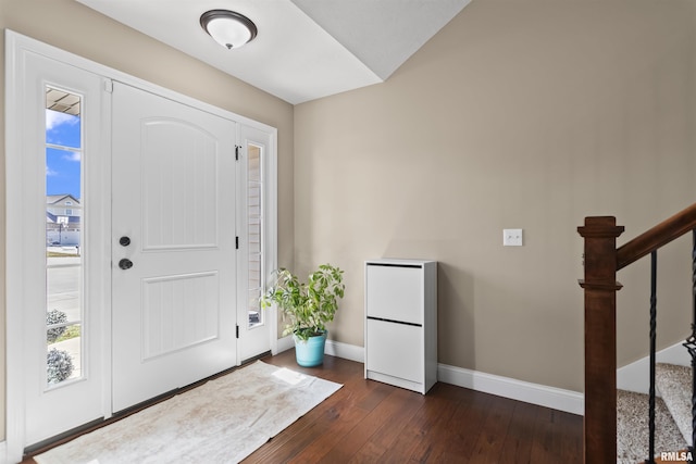 entryway featuring stairway, baseboards, dark wood-type flooring, and plenty of natural light