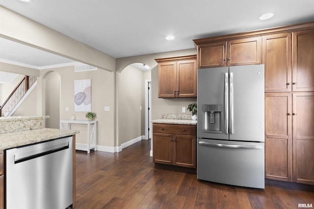 kitchen featuring visible vents, dark wood-style floors, arched walkways, appliances with stainless steel finishes, and light stone countertops