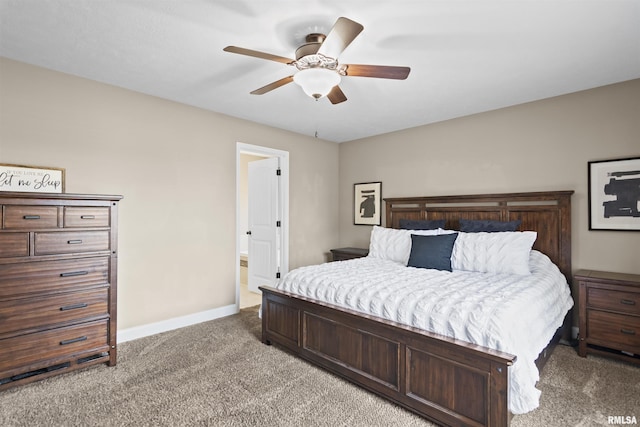 bedroom with connected bathroom, light colored carpet, baseboards, and ceiling fan