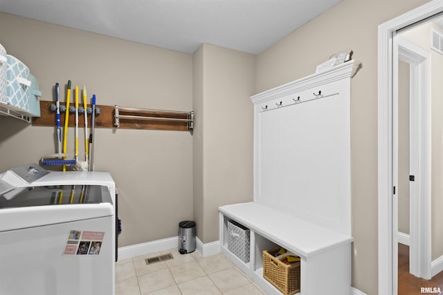 clothes washing area featuring baseboards, visible vents, laundry area, tile patterned flooring, and washer and clothes dryer