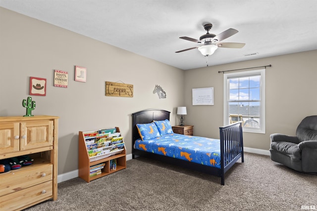 carpeted bedroom featuring a ceiling fan, visible vents, and baseboards