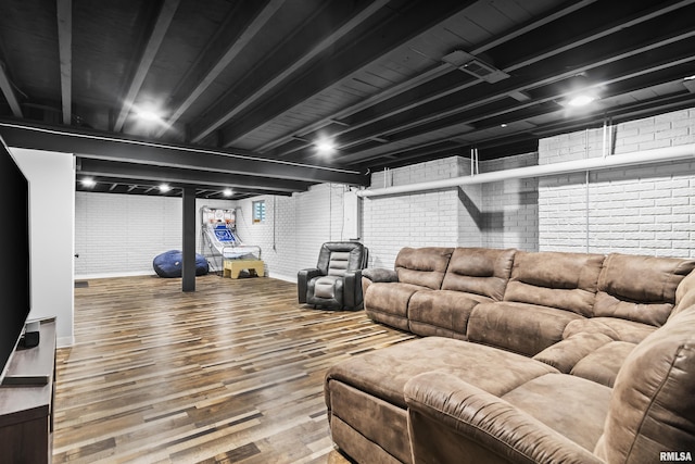 living room featuring wood finished floors and brick wall