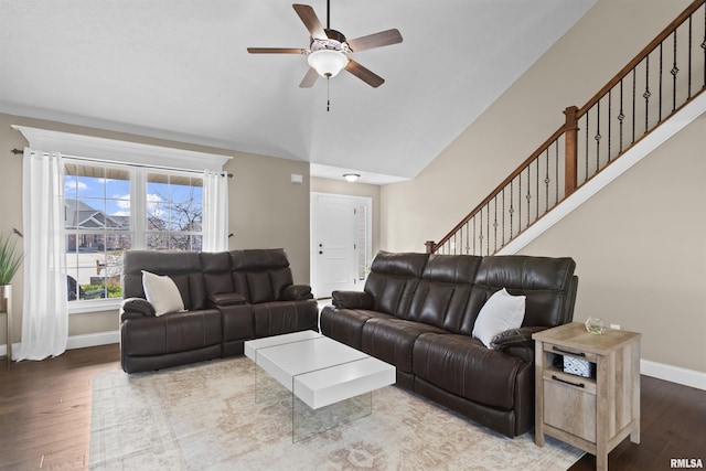 living area with baseboards, lofted ceiling, and wood finished floors