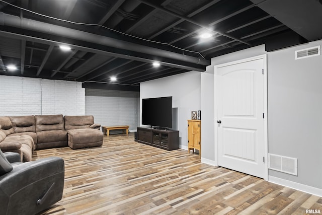 living area featuring wood finished floors, visible vents, and baseboards