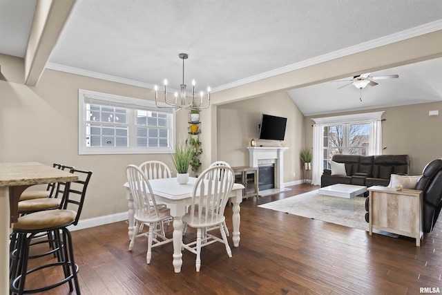 dining area featuring a high end fireplace, dark wood-type flooring, baseboards, lofted ceiling, and ceiling fan with notable chandelier