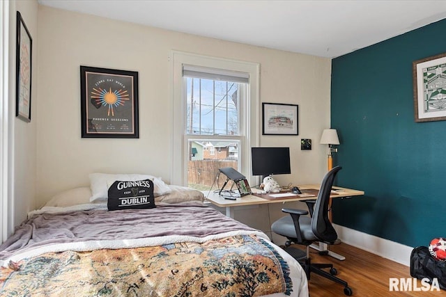 bedroom with wood finished floors and baseboards