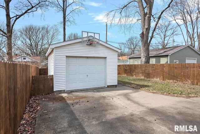 detached garage with concrete driveway and fence