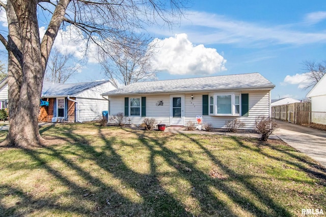 ranch-style house featuring a front yard and fence