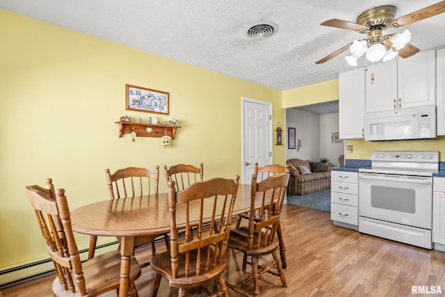 dining area with light wood-type flooring, visible vents, a textured ceiling, and ceiling fan