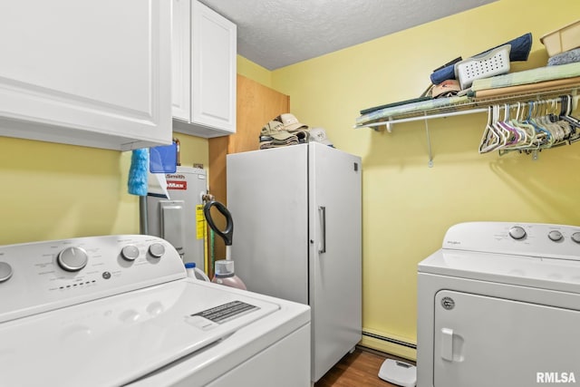 washroom with washing machine and clothes dryer, water heater, cabinet space, a textured ceiling, and a baseboard radiator