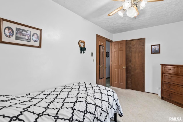 carpeted bedroom featuring a closet, a textured ceiling, and a ceiling fan