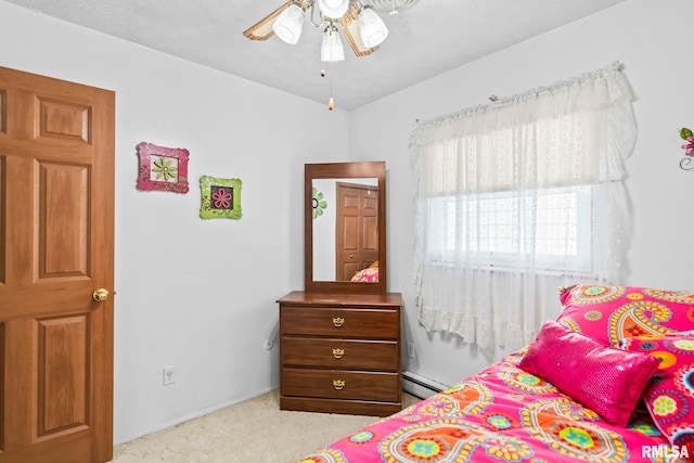 bedroom with a baseboard heating unit and carpet flooring